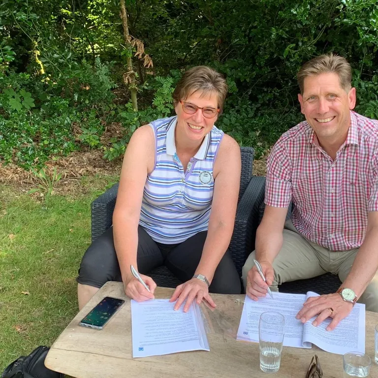 Marco and Sandra sign the papers to their new house