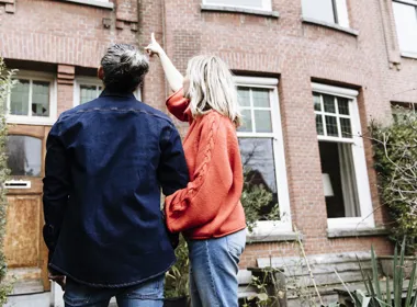 Stel wijst naar woning - De Hypotheker