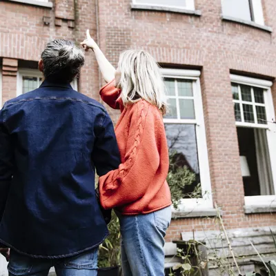 Stel wijst naar woning - De Hypotheker