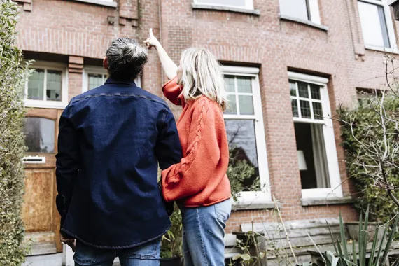 Stel wijst naar woning - De Hypotheker