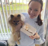 Christiana en haar hondje vieren dat haar bord geaccepteerd is met een gebakje