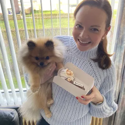 Christiana en haar hondje vieren dat haar bord geaccepteerd is met een gebakje