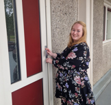 Felicia voor de voordeur van haar nieuwe woning