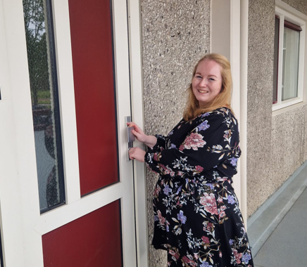 Felicia voor de voordeur van haar nieuwe woning