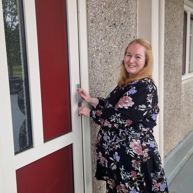 Felicia voor de voordeur van haar nieuwe woning