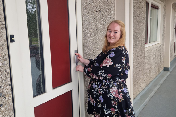 Felicia voor de voordeur van haar nieuwe woning