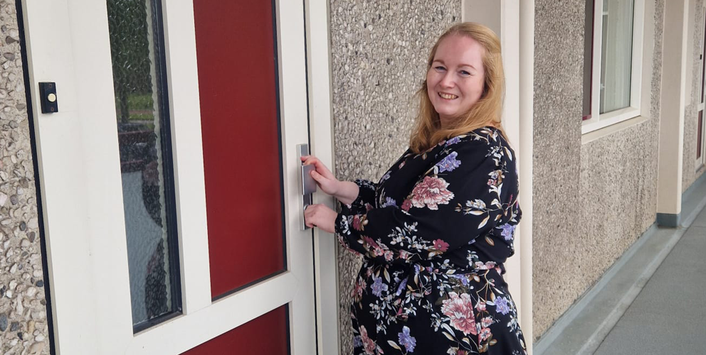 Felicia voor de voordeur van haar nieuwe woning